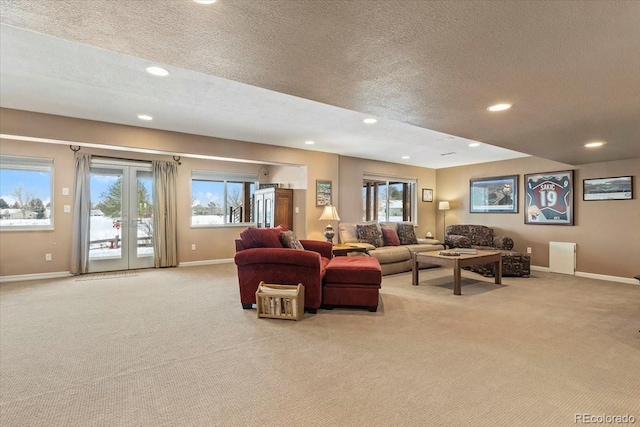 carpeted living room featuring a textured ceiling and french doors