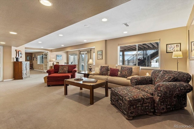 living room featuring light carpet and a textured ceiling