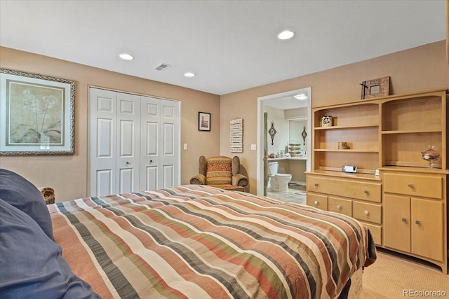 carpeted bedroom featuring ensuite bathroom and a closet