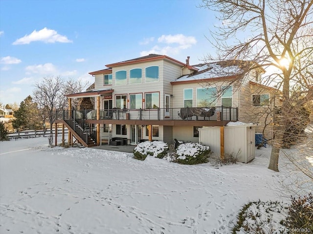 snow covered house featuring a wooden deck