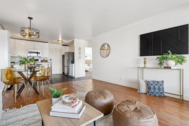 living room with an inviting chandelier and light wood-type flooring