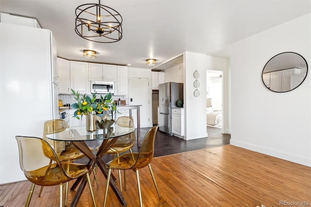 dining space featuring dark wood-type flooring and an inviting chandelier