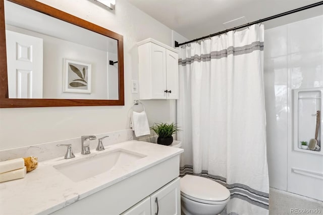 bathroom featuring vanity, walk in shower, and toilet