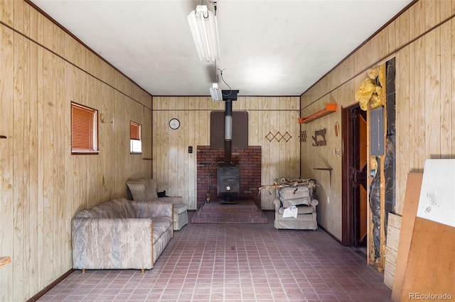 unfurnished living room with a wood stove, electric panel, and wooden walls