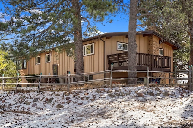 snow covered property with a deck