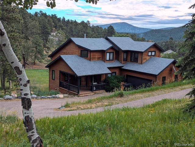 view of front facade featuring a mountain view and a shingled roof