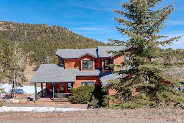 view of front of property with a view of trees and covered porch