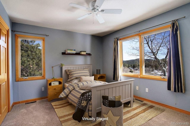 carpeted bedroom featuring visible vents, a ceiling fan, and baseboards