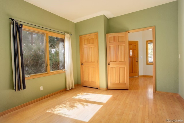 unfurnished bedroom featuring baseboards and hardwood / wood-style flooring