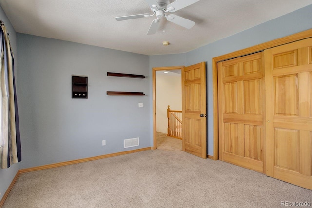 unfurnished bedroom with a closet, a ceiling fan, baseboards, and carpet floors