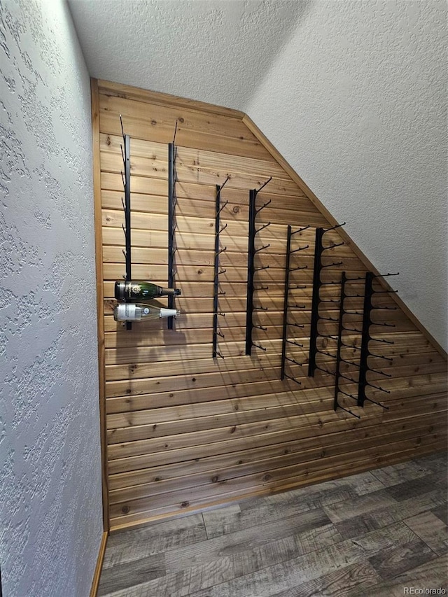 interior details with wood finished floors, a textured wall, and a textured ceiling