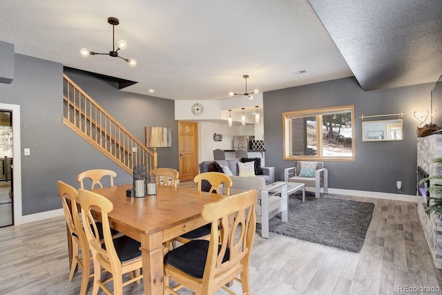 dining area featuring baseboards, a notable chandelier, and light wood finished floors