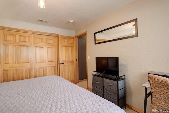 carpeted bedroom with baseboards, visible vents, and a textured ceiling