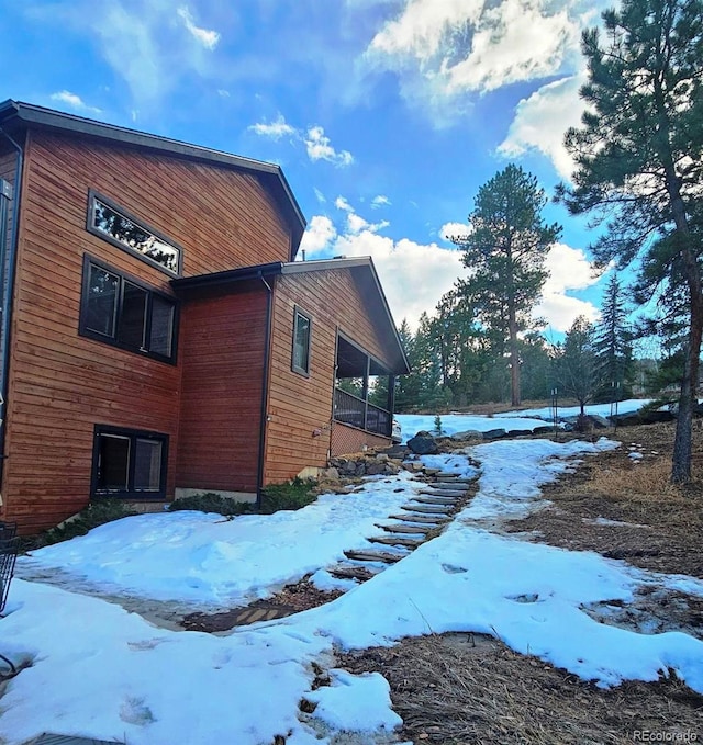 view of snow covered exterior featuring a sunroom