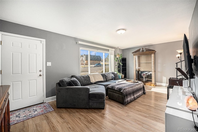 living area featuring light wood-style floors and baseboards