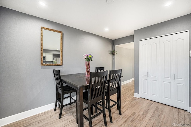 dining room featuring light wood finished floors, recessed lighting, and baseboards