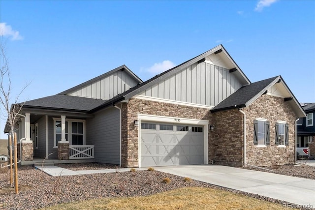 craftsman inspired home featuring board and batten siding, stone siding, a garage, covered porch, and driveway