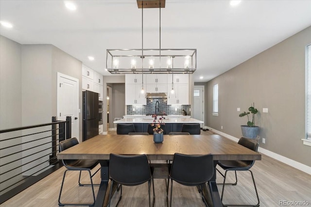 dining room featuring light wood-style flooring, baseboards, and recessed lighting