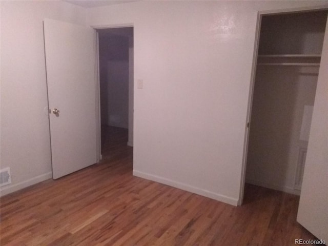 unfurnished bedroom featuring hardwood / wood-style floors and a closet