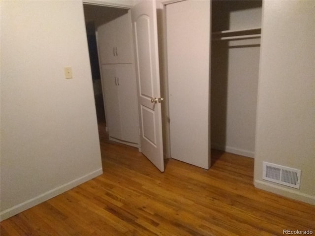 unfurnished bedroom with a closet and light hardwood / wood-style floors