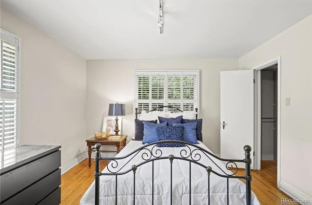 6235 E 6th Avenue Parkway, Denver, CO 80220 - bedroom featuring baseboards, light wood-type flooring, and track lighting