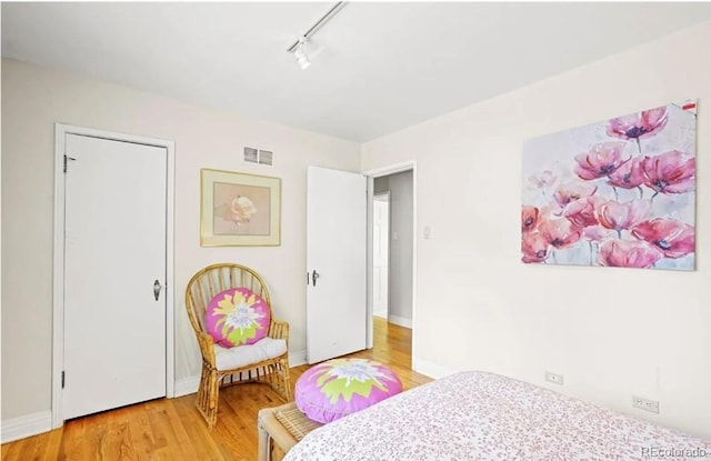 6235 E 6th Avenue Parkway, Denver, CO 80220 - bedroom featuring track lighting, baseboards, visible vents, and light wood-style floors