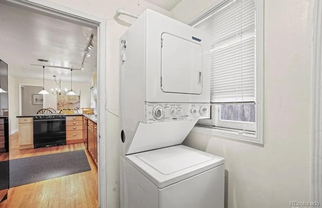 6235 E 6th Avenue Parkway, Denver, CO 80220 - clothes washing area with light wood finished floors, laundry area, track lighting, and stacked washer and dryer