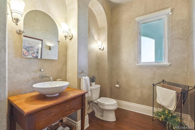 bathroom with hardwood / wood-style floors, vanity, and toilet