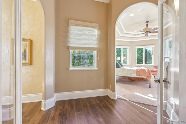 interior space featuring ceiling fan, dark hardwood / wood-style floors, ornamental molding, and a tray ceiling