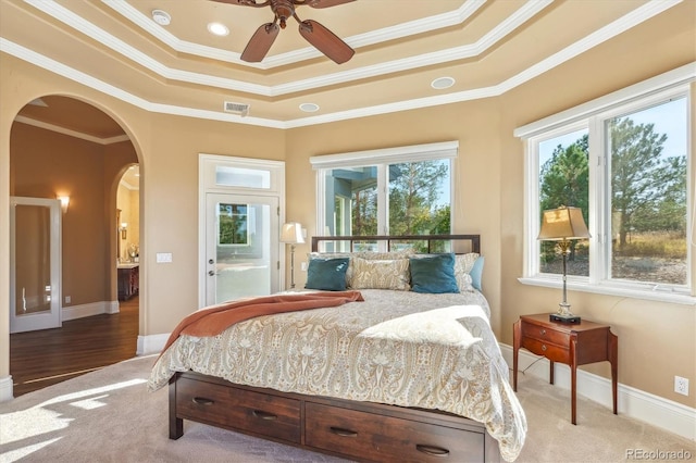 bedroom with ornamental molding, wood-type flooring, ceiling fan, and a raised ceiling