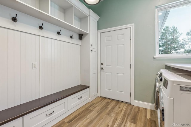 mudroom with light hardwood / wood-style flooring and independent washer and dryer