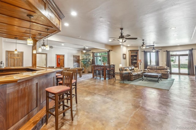 living room featuring bar area and concrete flooring