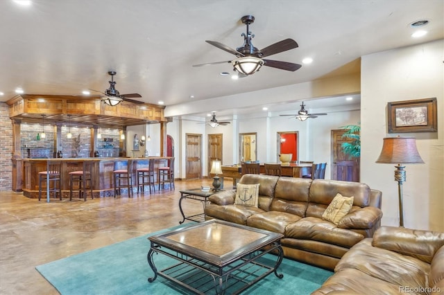 living room featuring concrete flooring and bar