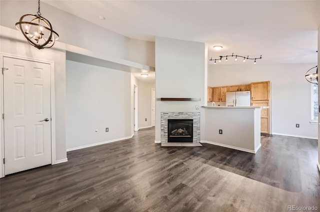 unfurnished living room featuring dark wood-type flooring and a chandelier