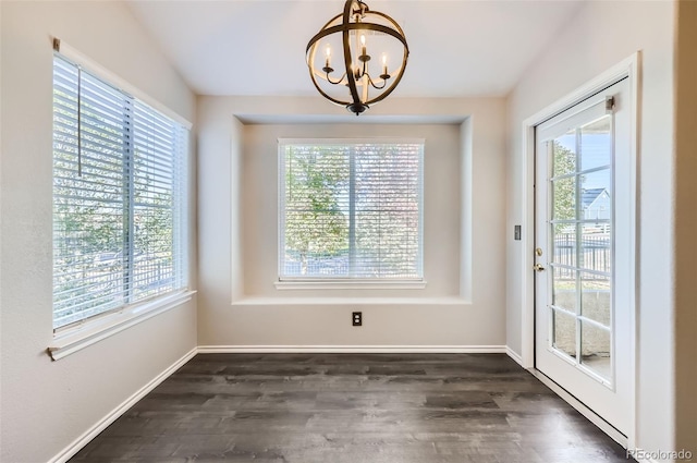 unfurnished dining area featuring plenty of natural light, a chandelier, and dark hardwood / wood-style flooring