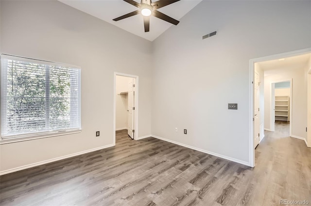 unfurnished room featuring ceiling fan, wood-type flooring, and high vaulted ceiling