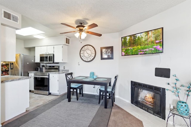 kitchen with appliances with stainless steel finishes, light countertops, visible vents, and white cabinetry