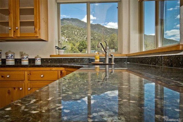 4417 Twinview Ct, Crestone, CO 81131 - kitchen with a mountain view, glass insert cabinets, brown cabinets, and dark stone counters
