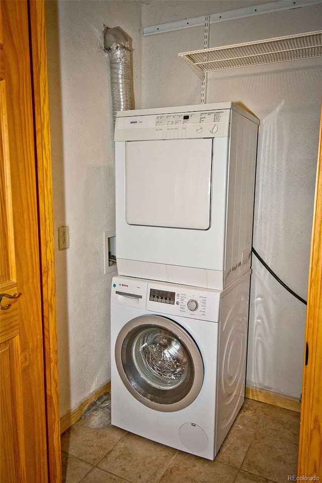 4417 Twinview Ct, Crestone, CO 81131 - laundry room featuring stacked washing machine and dryer, tile patterned flooring, and baseboards