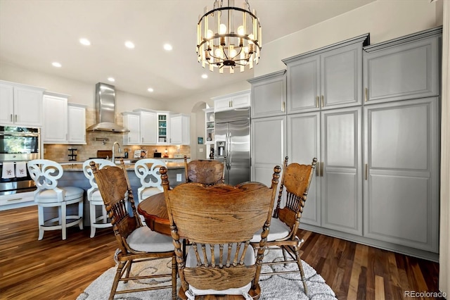 dining room with dark hardwood / wood-style flooring and a chandelier