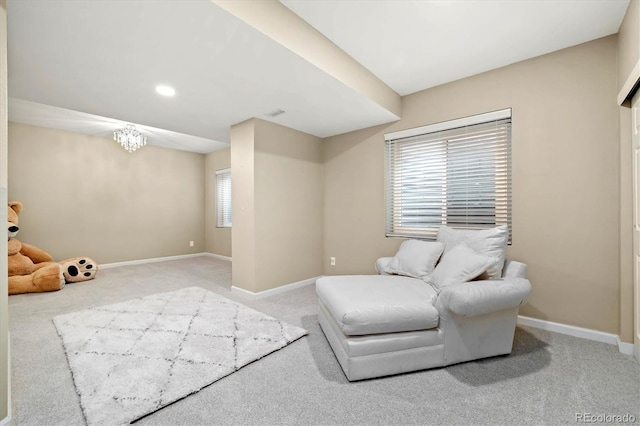 living area featuring carpet flooring, an inviting chandelier, and a healthy amount of sunlight