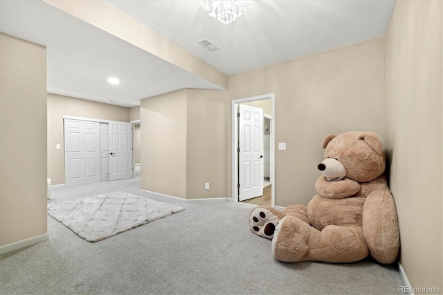 playroom with light carpet and a notable chandelier