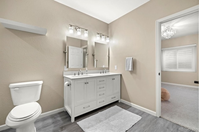 bathroom featuring hardwood / wood-style flooring, vanity, toilet, and a chandelier