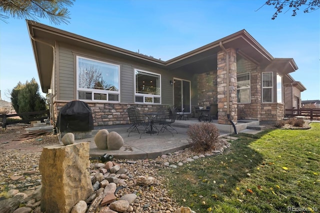 rear view of property featuring a yard and a patio area