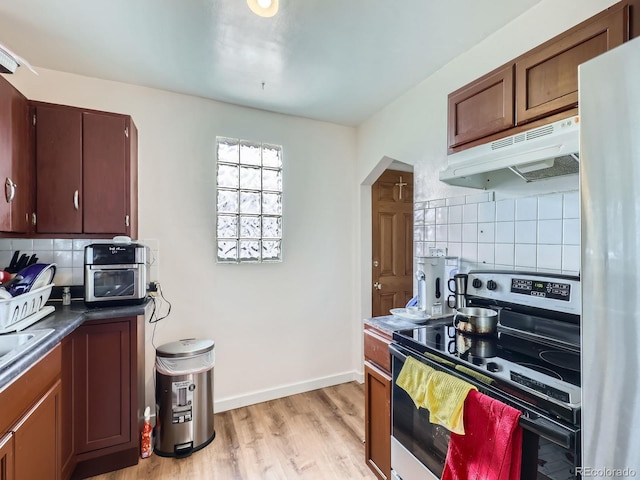 kitchen with stainless steel range with electric stovetop, tasteful backsplash, light hardwood / wood-style floors, and refrigerator