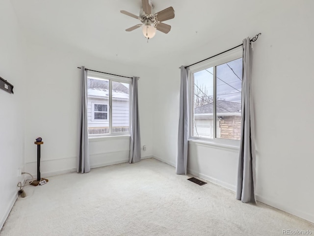 carpeted spare room with ceiling fan