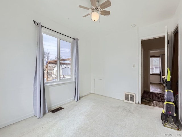 carpeted spare room featuring ceiling fan