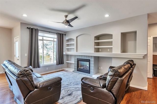 4630 Whitehall Ln, Highlands Ranch, CO 80126 - living room with ceiling fan, wood finished floors, a tiled fireplace, built in features, and recessed lighting
