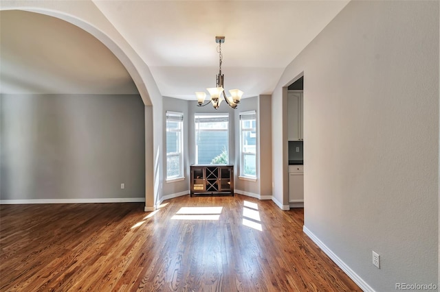4630 Whitehall Ln, Highlands Ranch, CO 80126 - unfurnished dining area with dark wood-style flooring, a chandelier, and arched walkways