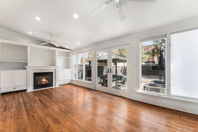 unfurnished living room with a fireplace with flush hearth, wood finished floors, recessed lighting, french doors, and ceiling fan